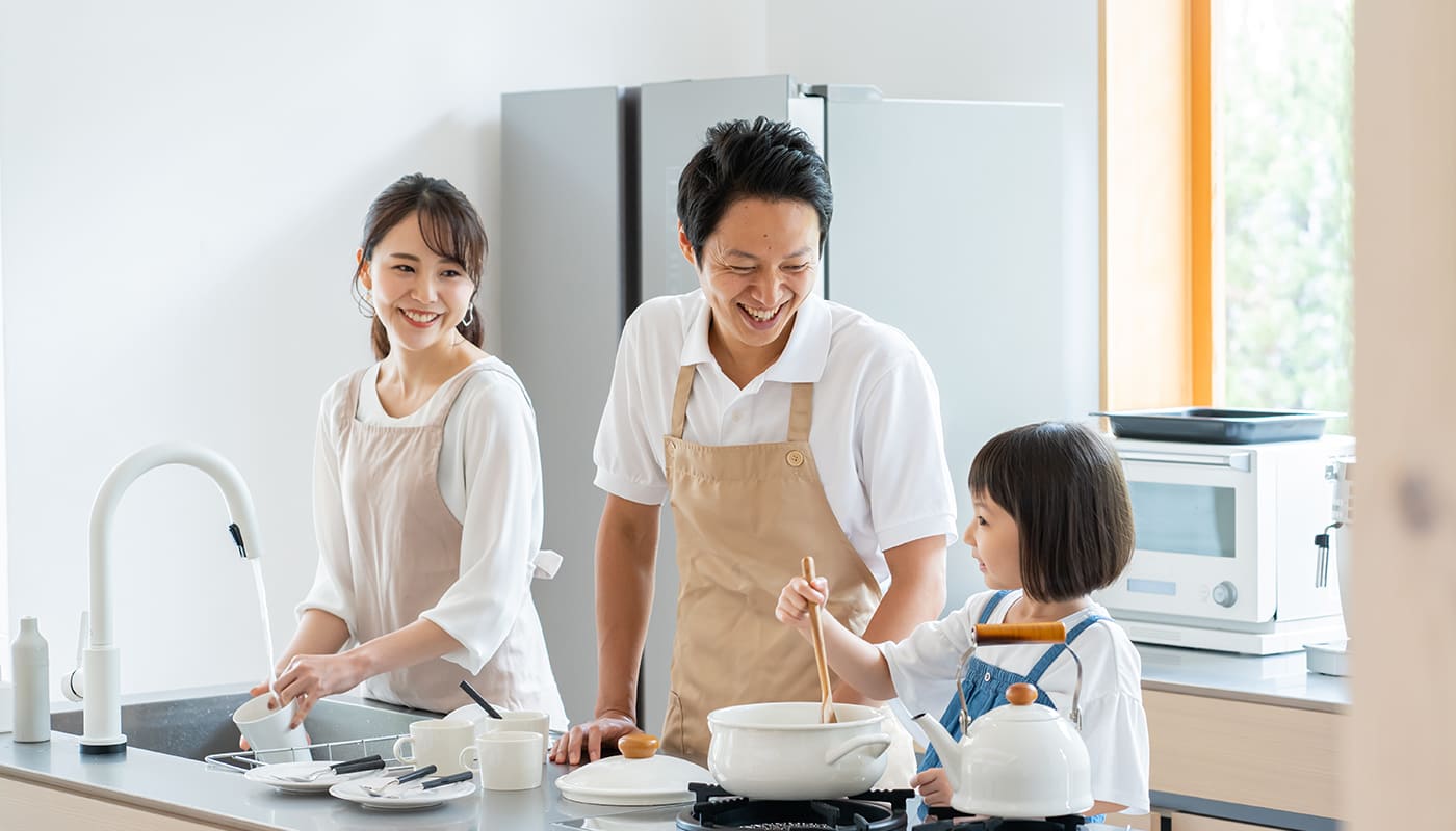 キッチンで料理する3人家族