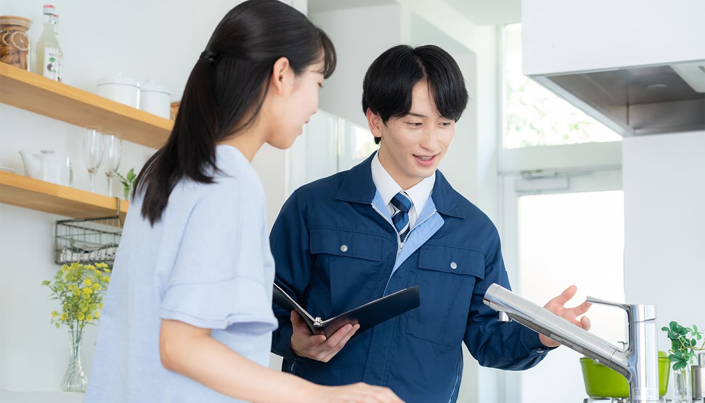 キッチンで作業員の説明を受ける女性