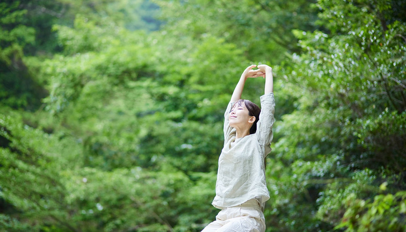 緑の中で深呼吸する女性