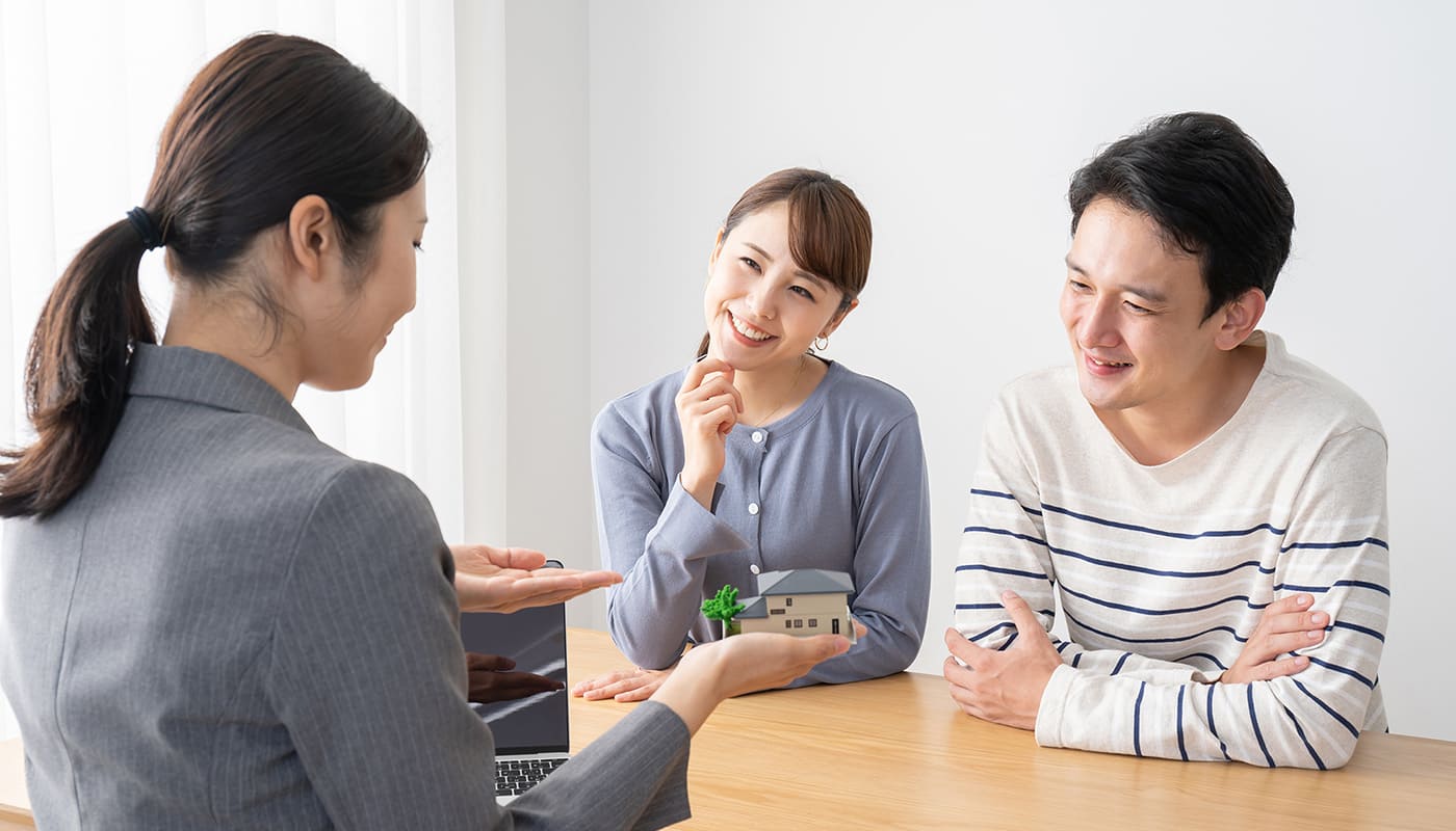 不動産を勧めるスタッフと悩む夫婦